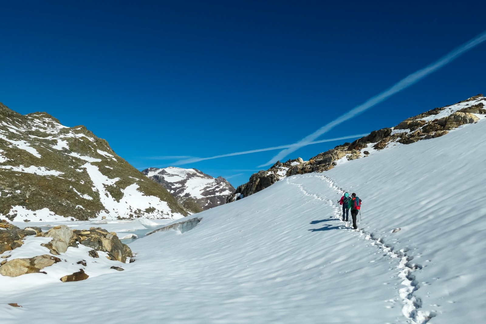Zwei Skitourengeher auf einem verschneiten Berg | Credit: iStock.com/Christopher Moswitzer