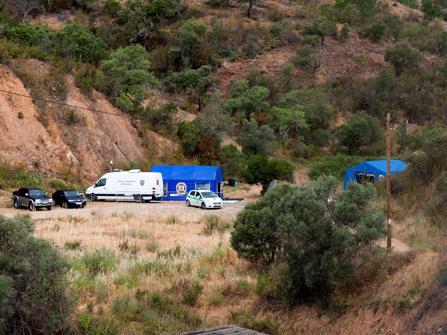 Polizeiautos mit Zelten vor einem Stausee in Portugal