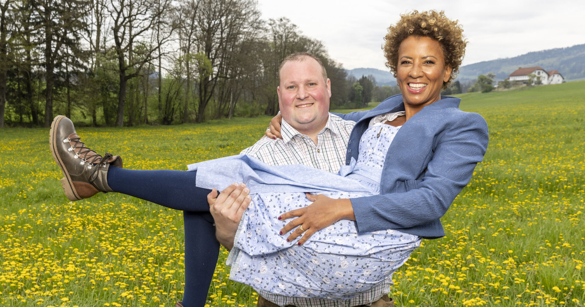 Bauer Christoph nimmt Arabella Kiesbauer auf die Arme.