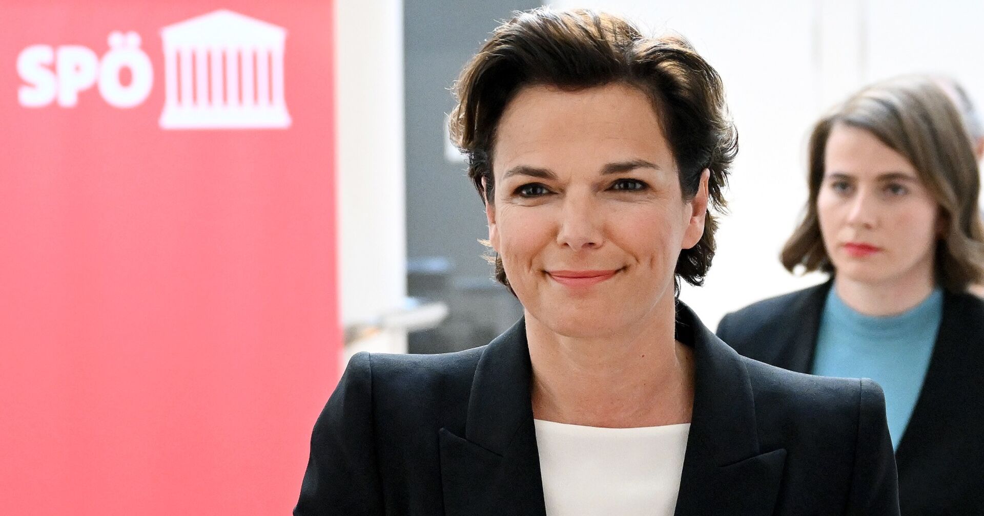Rendi-Wagner in Großaufnahme beim Gehen. Sie wirkt entspannt und gelöst, im Hintergrund ihre Pressesprecherin.