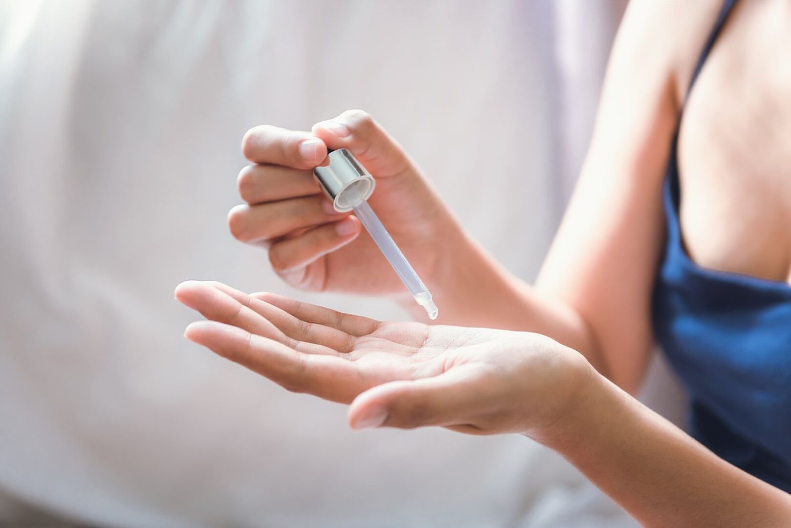 Frau gibt sich Serum in die Hand | Credit: iStock.com/12963734