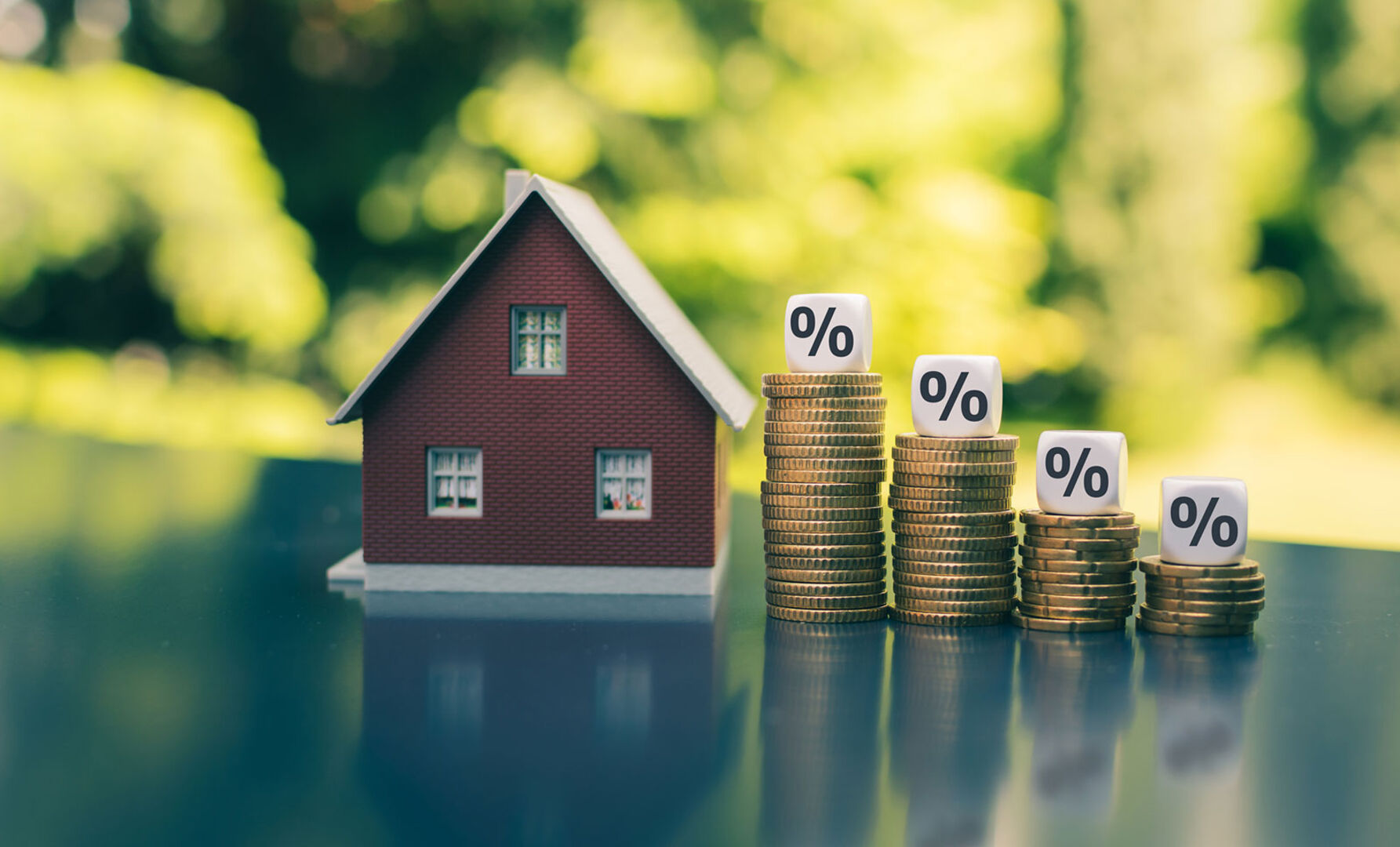 Miniatur-Haus mit Euro-Münzen und Prozentsymbolen drauf | Credit: iStock.com/Fokusiert