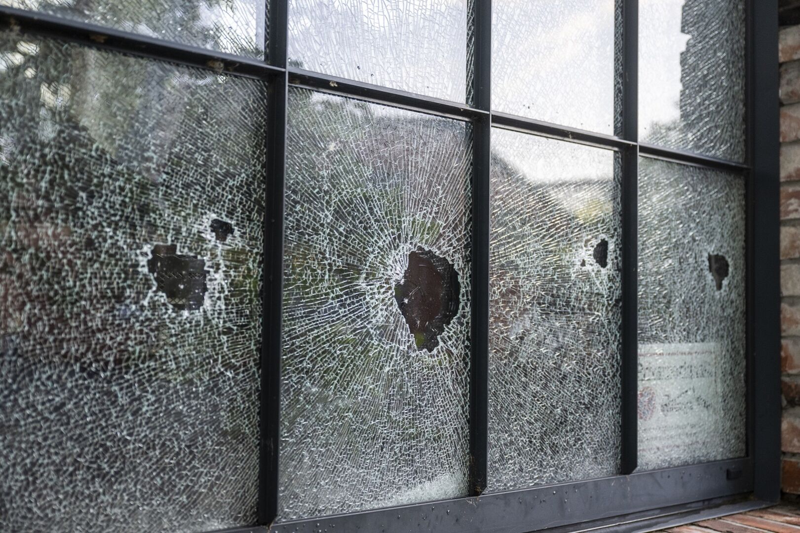 Eingeschlagene Fensterscheiben bei einem Backsteingebäude