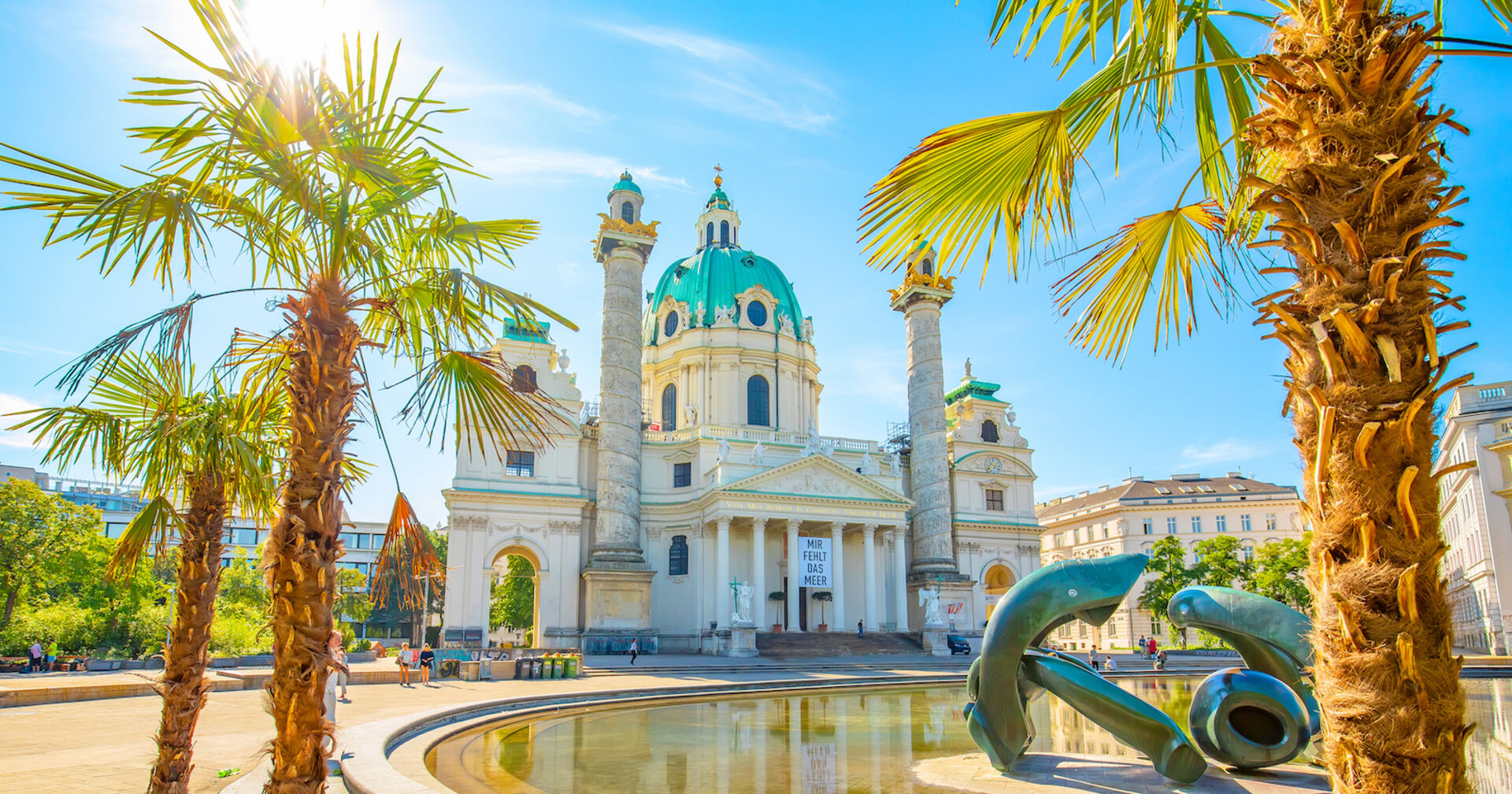 Palmen im Sonnenschein vor der Wiener Karlskirche | Credit: istock.com/arcady_31