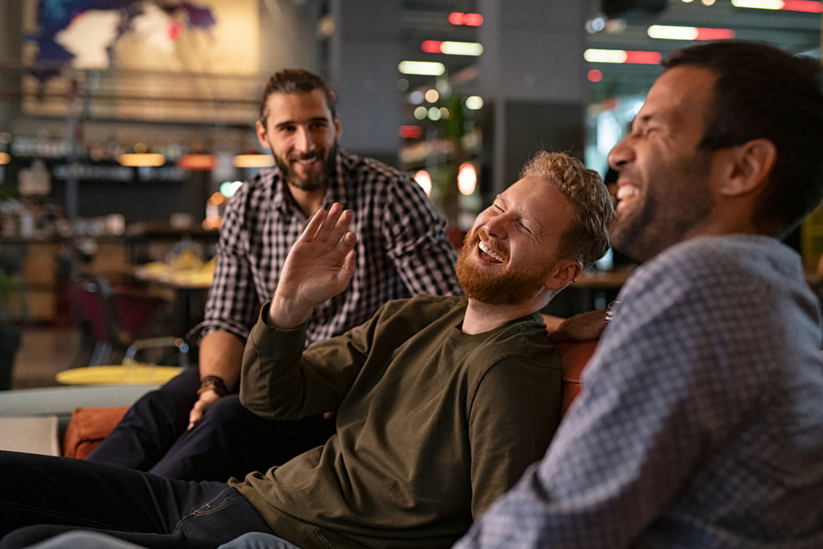 Männer sitzen zusammen und lachen | Credit: iStock.com/Ridofranz