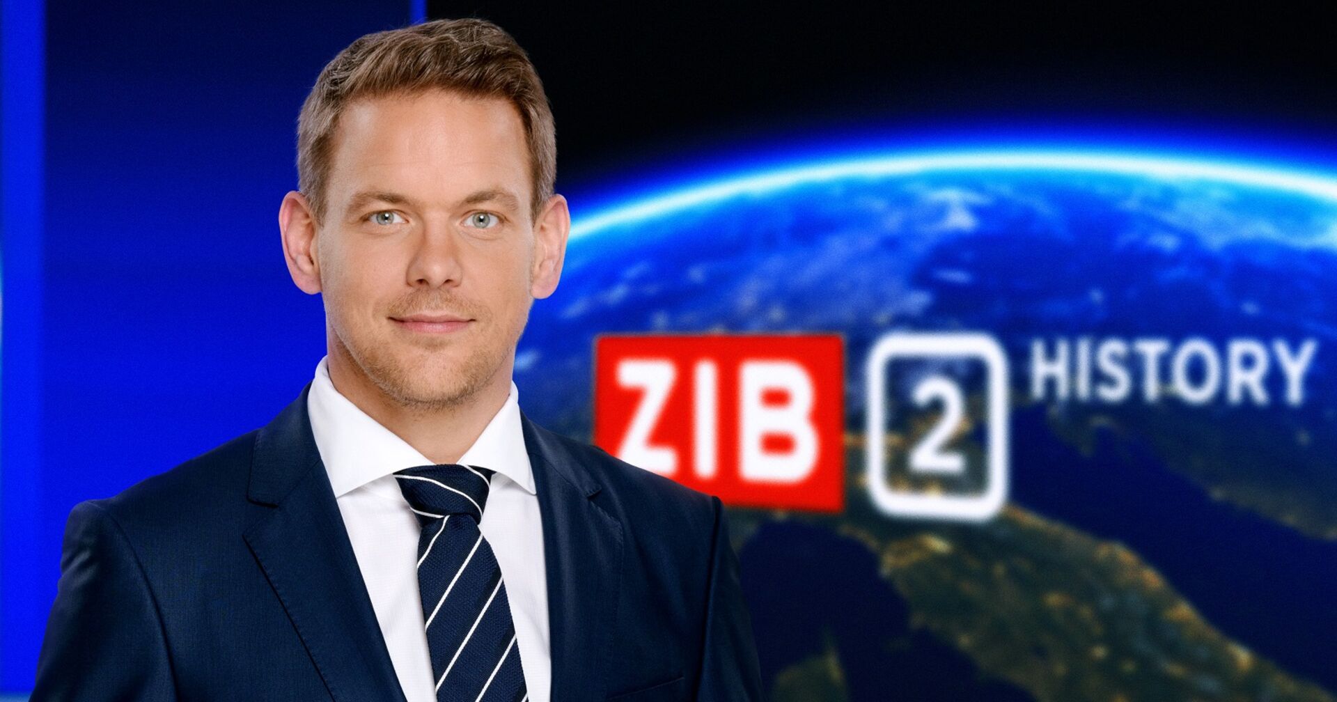Offizielles Foto von Martin Thür als Moderator im Anzug im ZIB Studio. Im Hintergrund eingeblendet: ZIB2 History