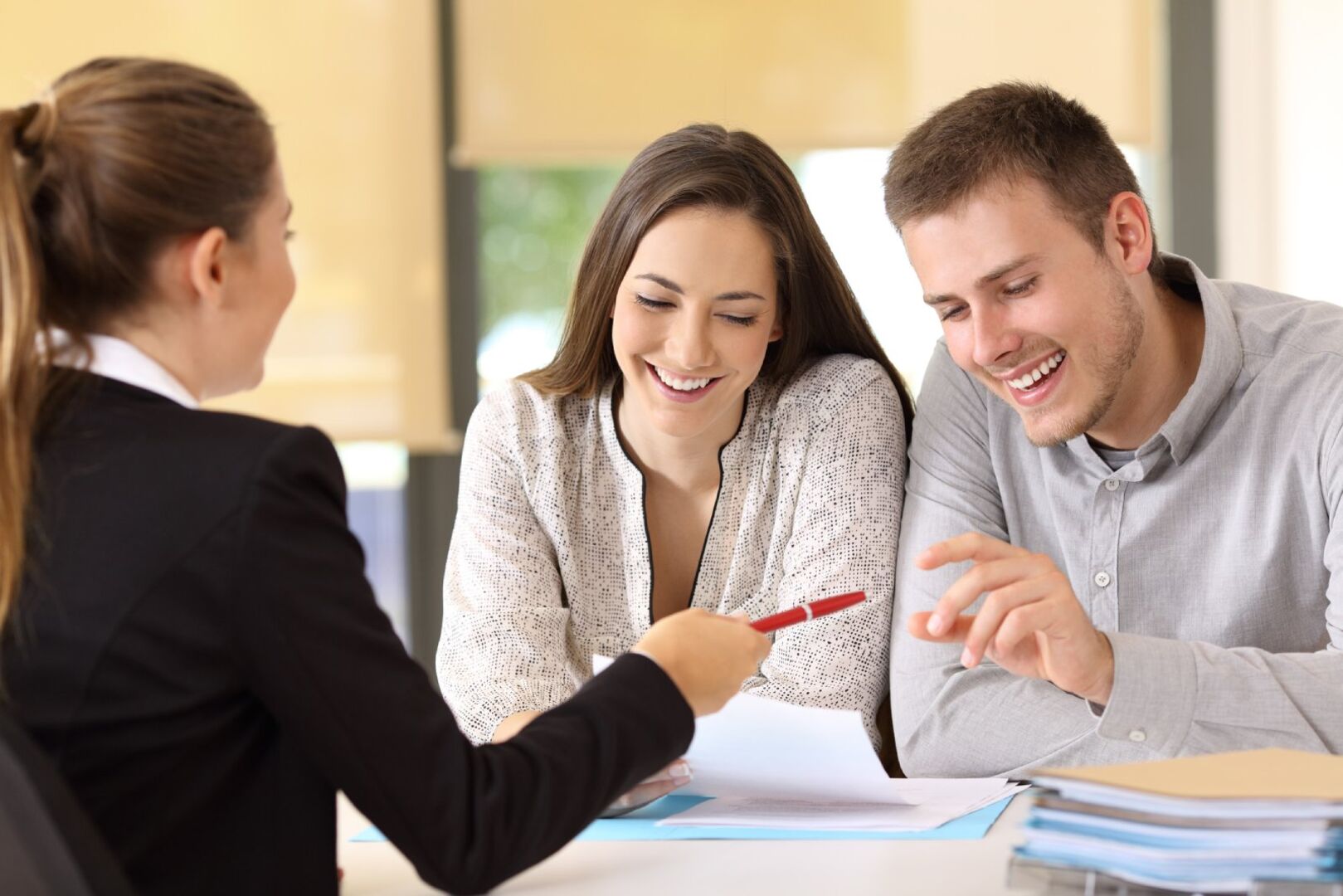 Paar unterzeichnet Kaufvertrag bei einer Notarin | Credit: iStock.com/AntonioGuillem
