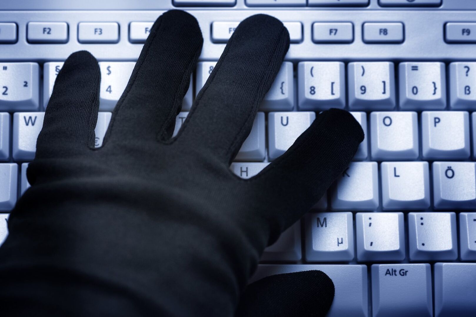 Hand mit Handschuh auf der Tastatur.