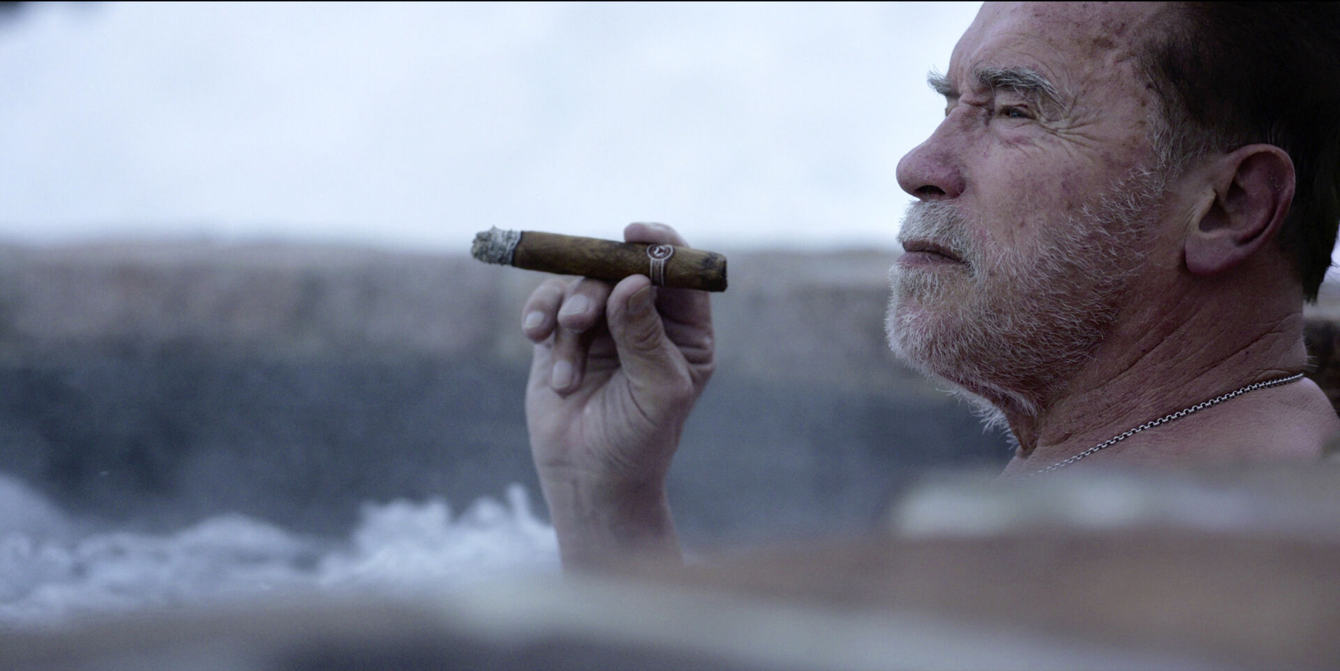 Arnold Schwarzenegger mit Zigarre im Whirlpool.
