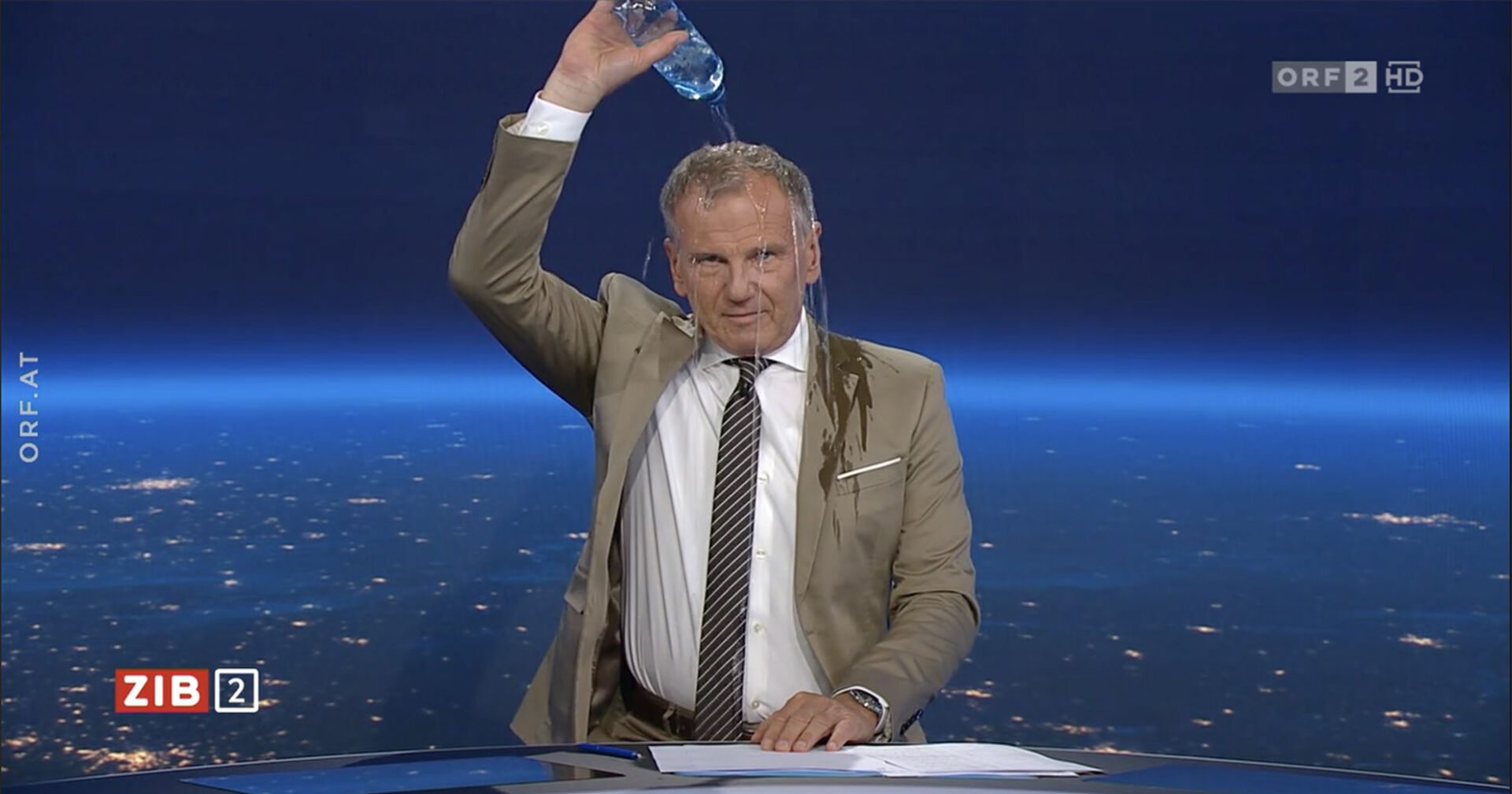 ZIB2-Moderator Armin Wolf schüttet sich in der Sendung eine Flasche Wasser über den Kopf