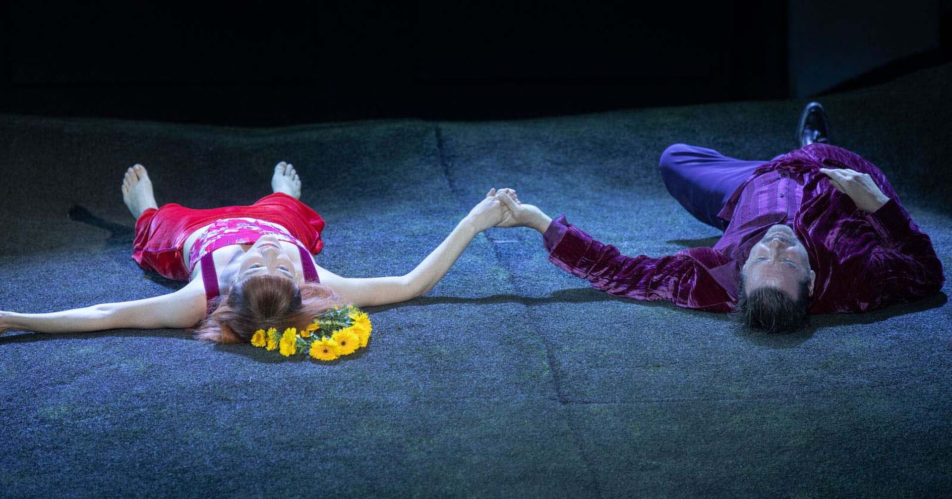 Die Buhlschaft und der Jedermann liegen händchenhaltend auf dem Boden.