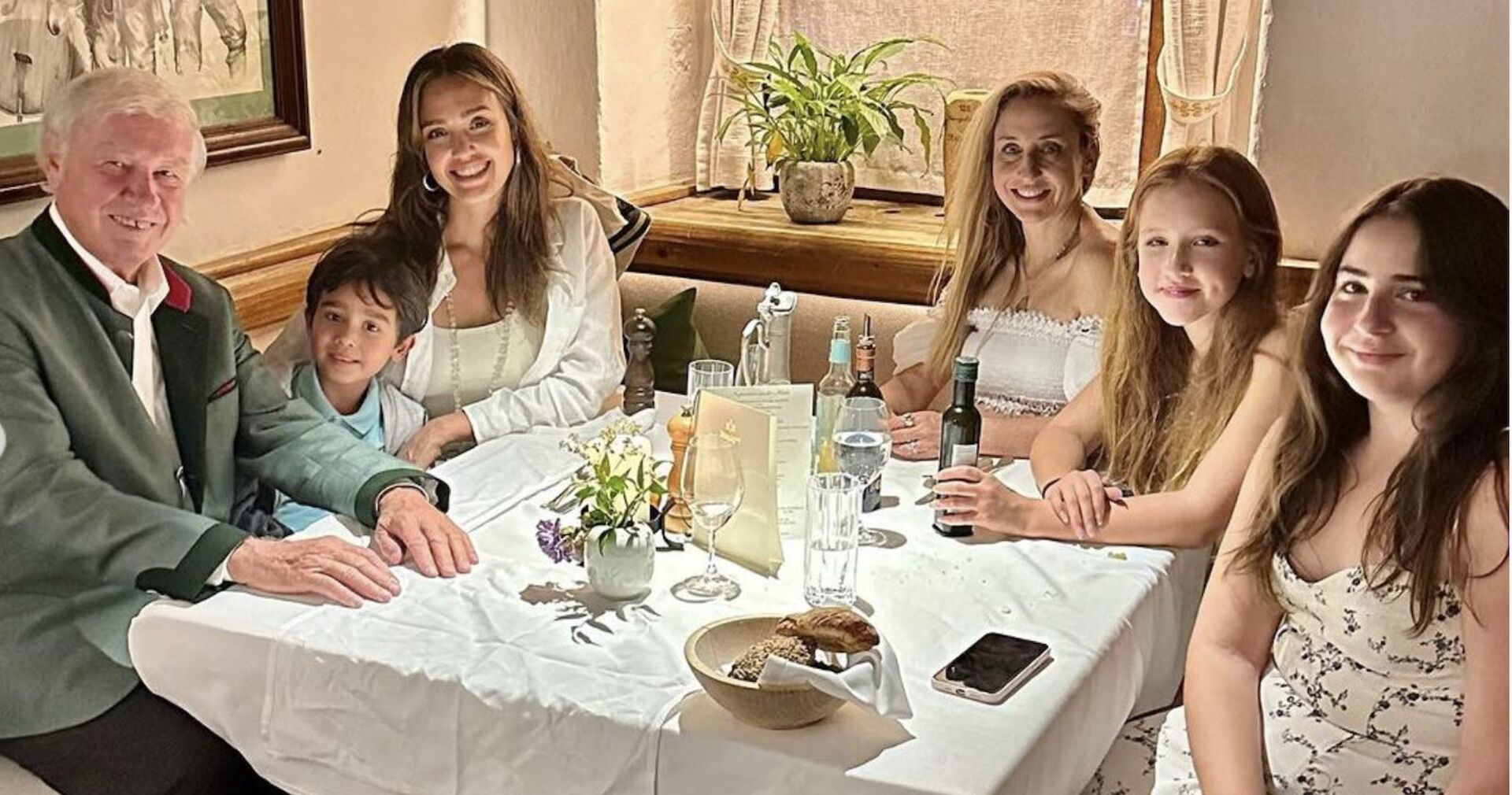 Jessica Alba sitzt mit ihren Kindern und Freunden beim Abendessen an einem Tisch im Stanglwirt.