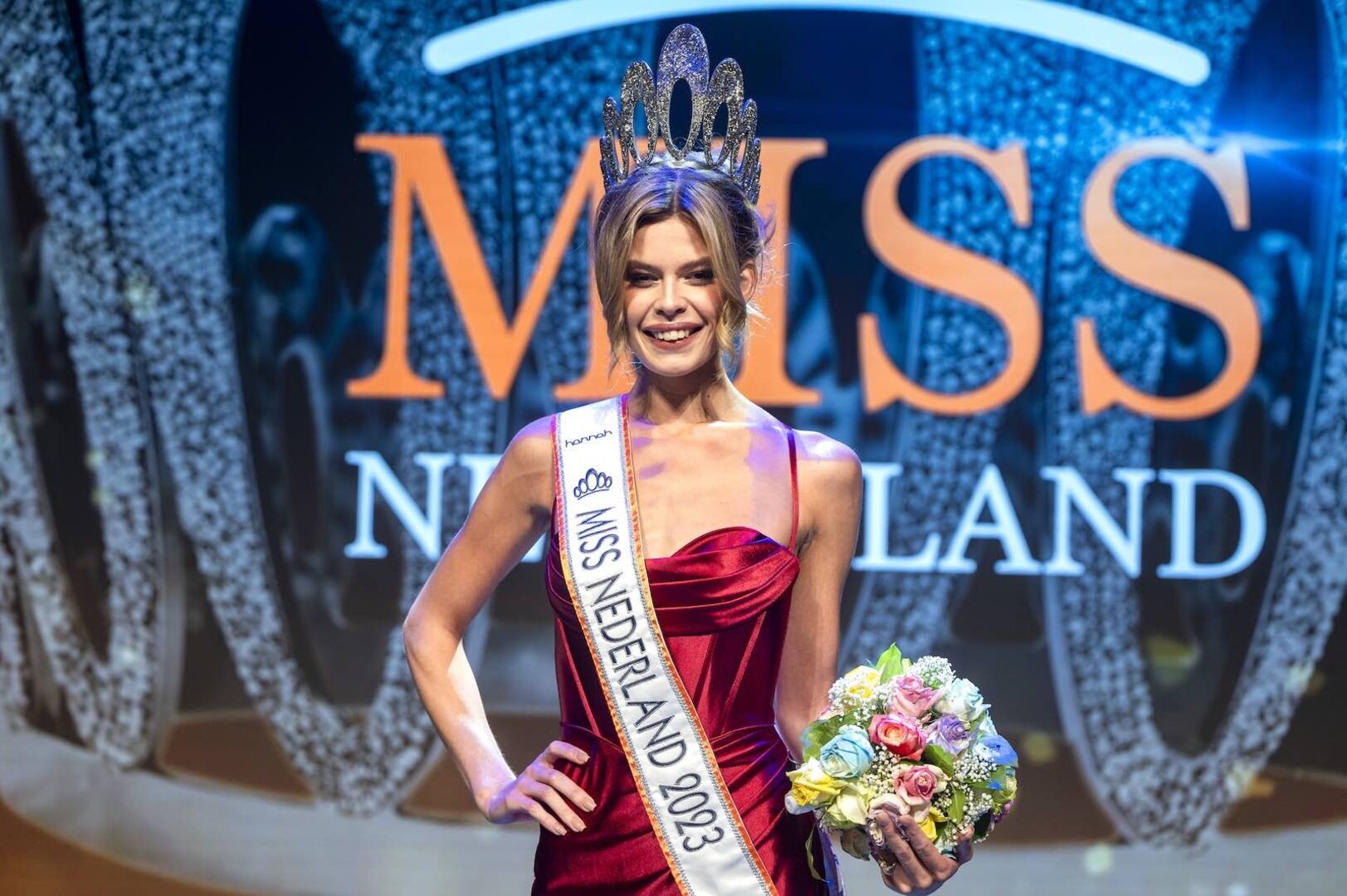 Rikkie Kolle mit rotem Kleid und Miss-Schleife.