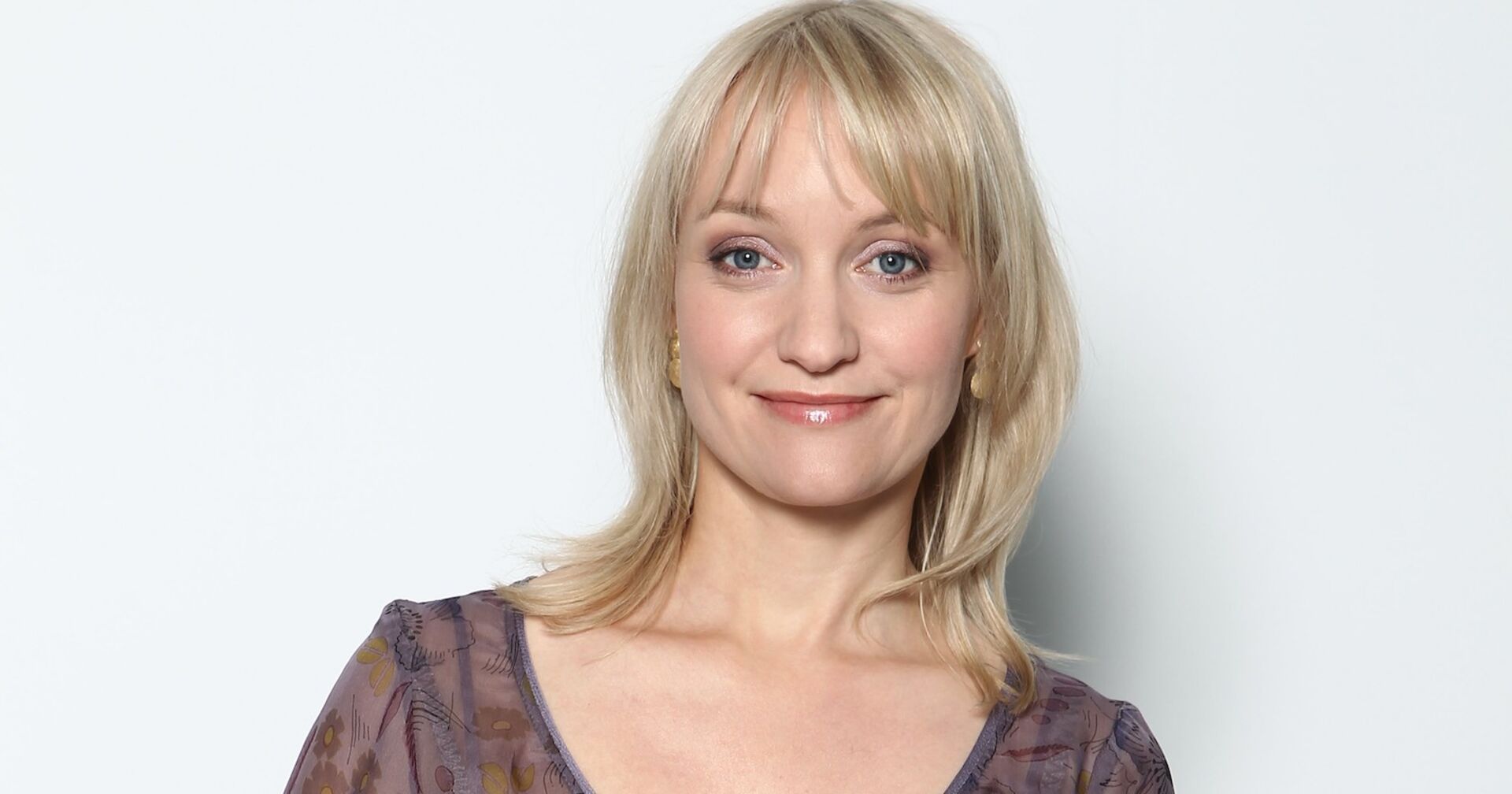 Eine blonde Frau schaut in die Kamera.