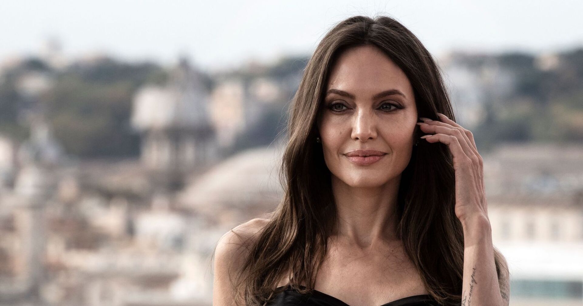 Angelina Jolie fährt sich mit der Hand durchs Haar.