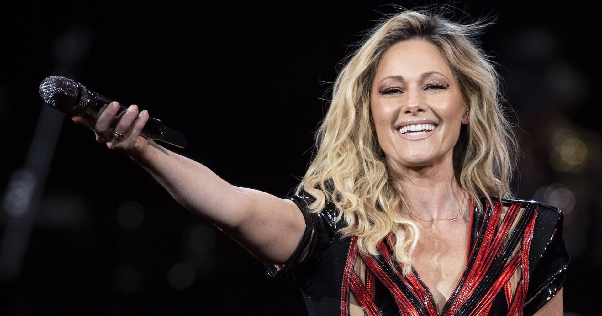 Helene Fischer lächelnd und mit Mikrofon auf der Bühne.