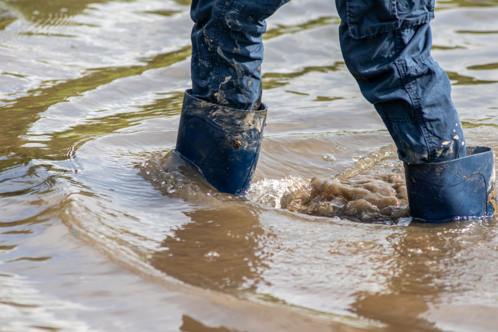 Mit Stiefeln in dreckigem Wasser