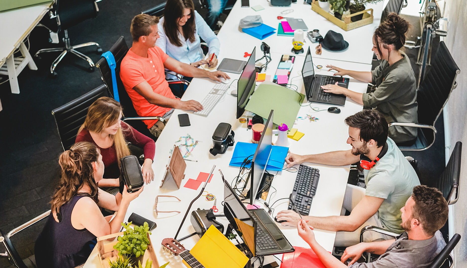Junge Menschen eines Teams arbeiten mit ihren Notebooks an einem Tisch | Credit: iStock.com/DisobeyArt