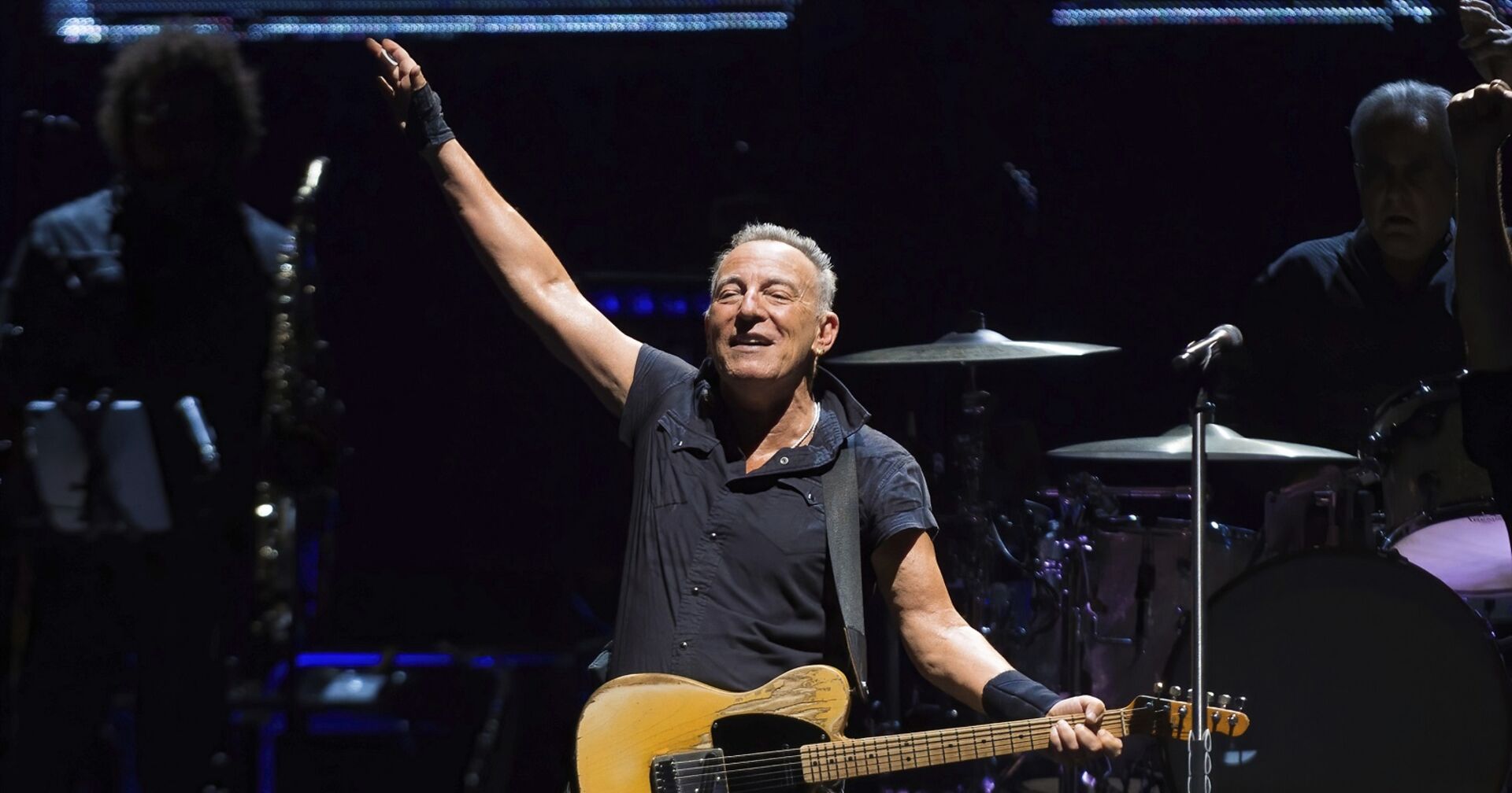 Bruce Springsteen hebt die Hand und singt auf der Bühne