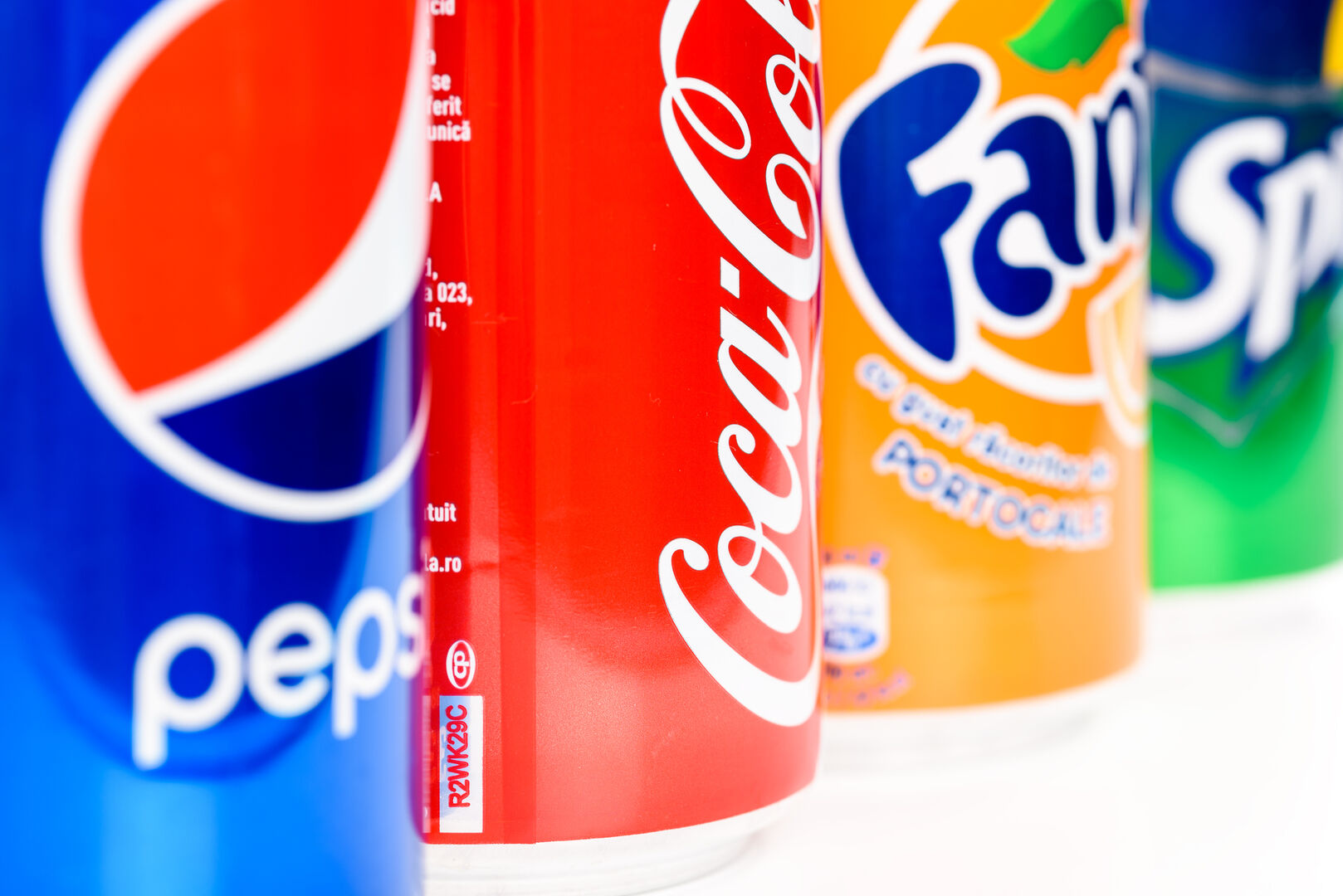 Pepsi-, Cola-, Fanta- und Sprite-Getränkedosen nebeneinander.