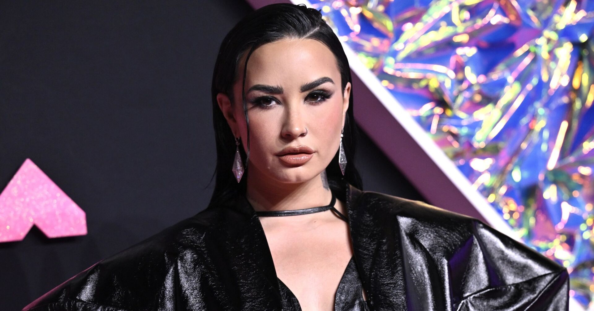 Demi Lovato mit Smokey Eyes und einem schwarzen Lackanzug am Red Carpet