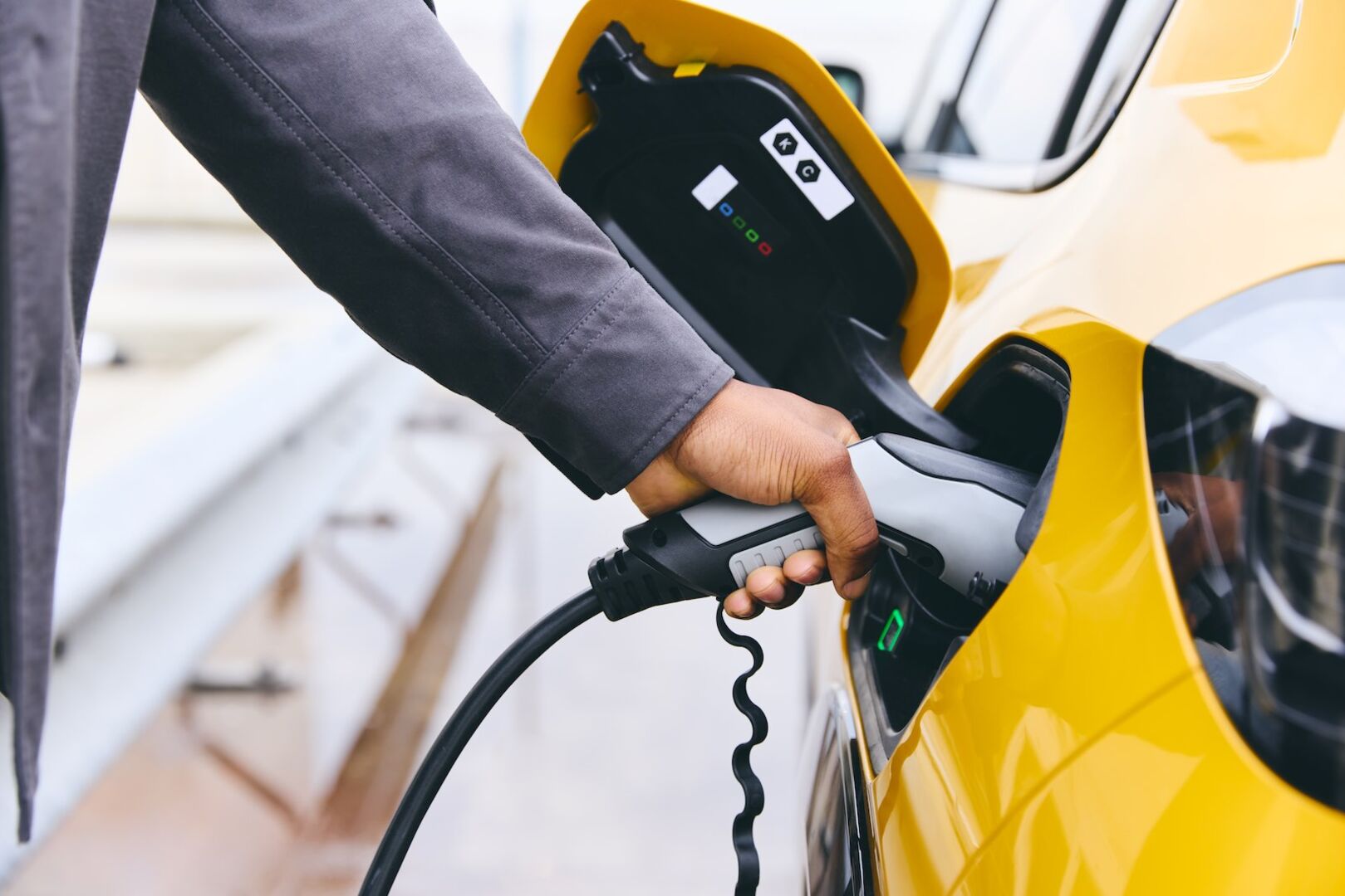 Ein Personen lädt ein gelbes E-Auto auf.