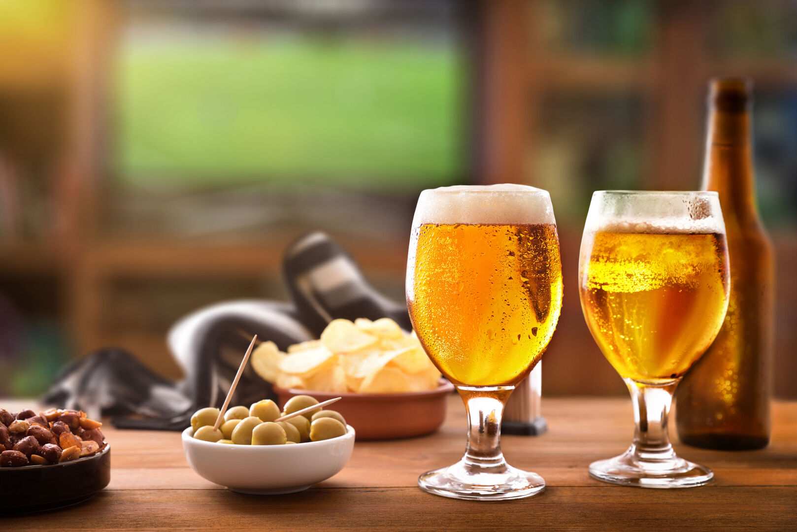 Verschiedene Schälchen mit Snacks und zwei Gläser Bier.