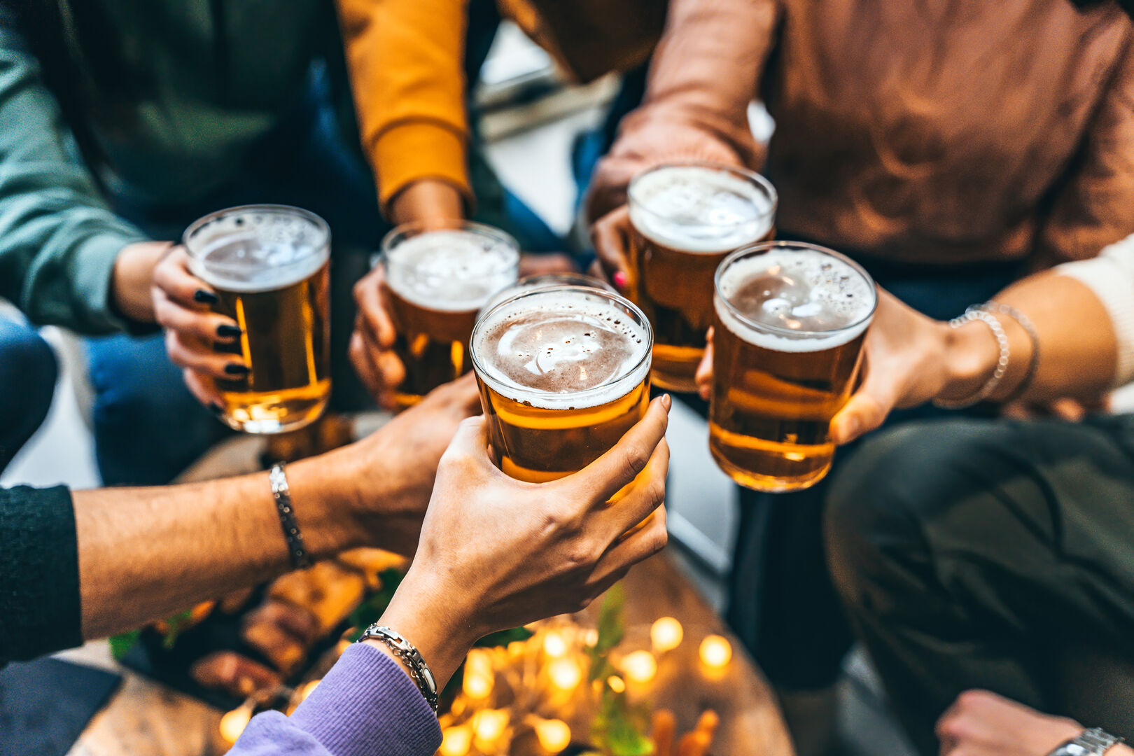 Mehrere Männder stoßen mit Bier an.