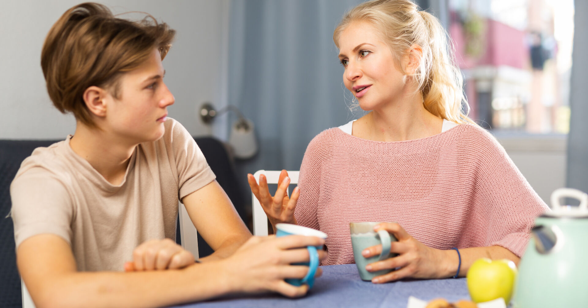 Sohn und Mutter sprechen beim Frühstück miteinander | Credit: istock.com/JackF