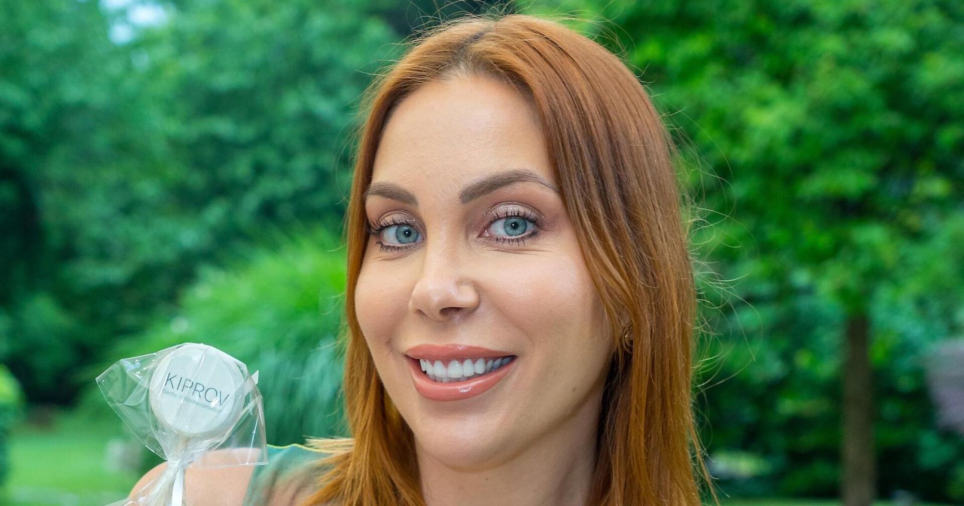 Tara Tabitha mit kupfer Haaren vor einem Park.