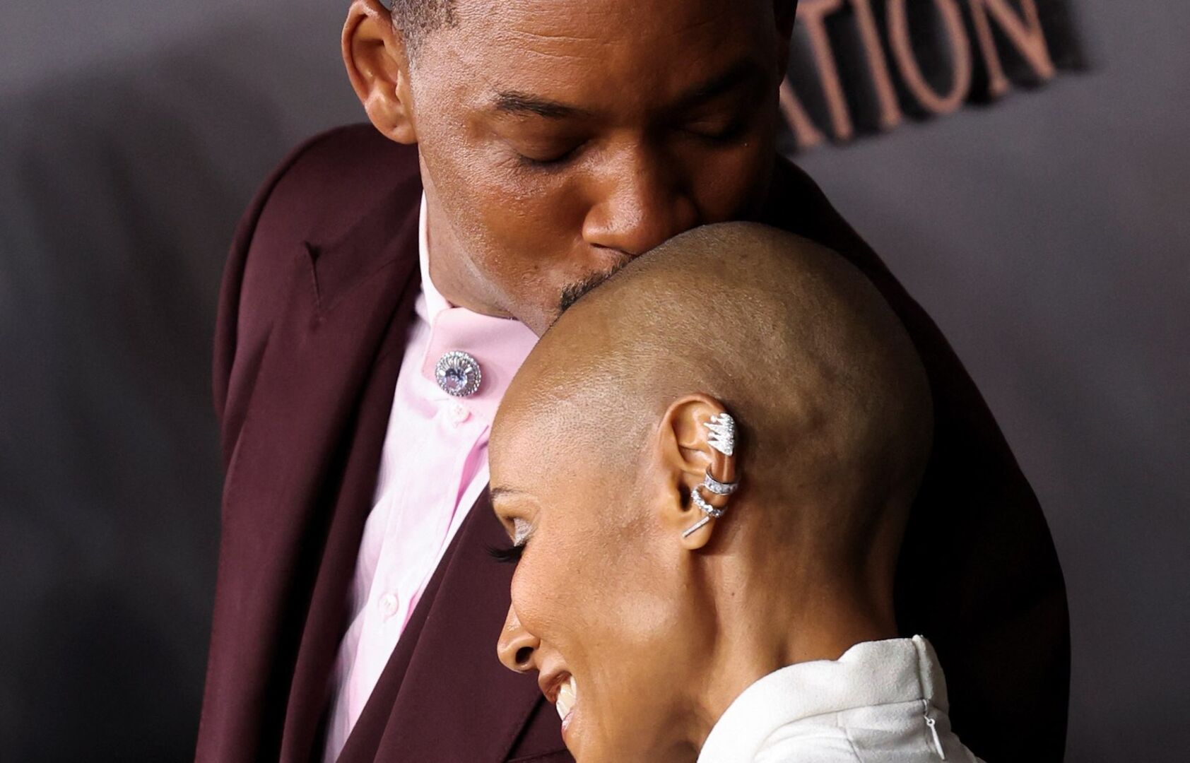 Will Smith küsst Jada Pinkett Smith auf den Kopf.