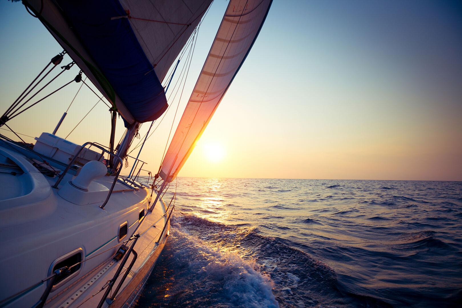 Segelboot auf dem Meer bei Sonnenuntergang | Credit: iStock.com/mihtiander