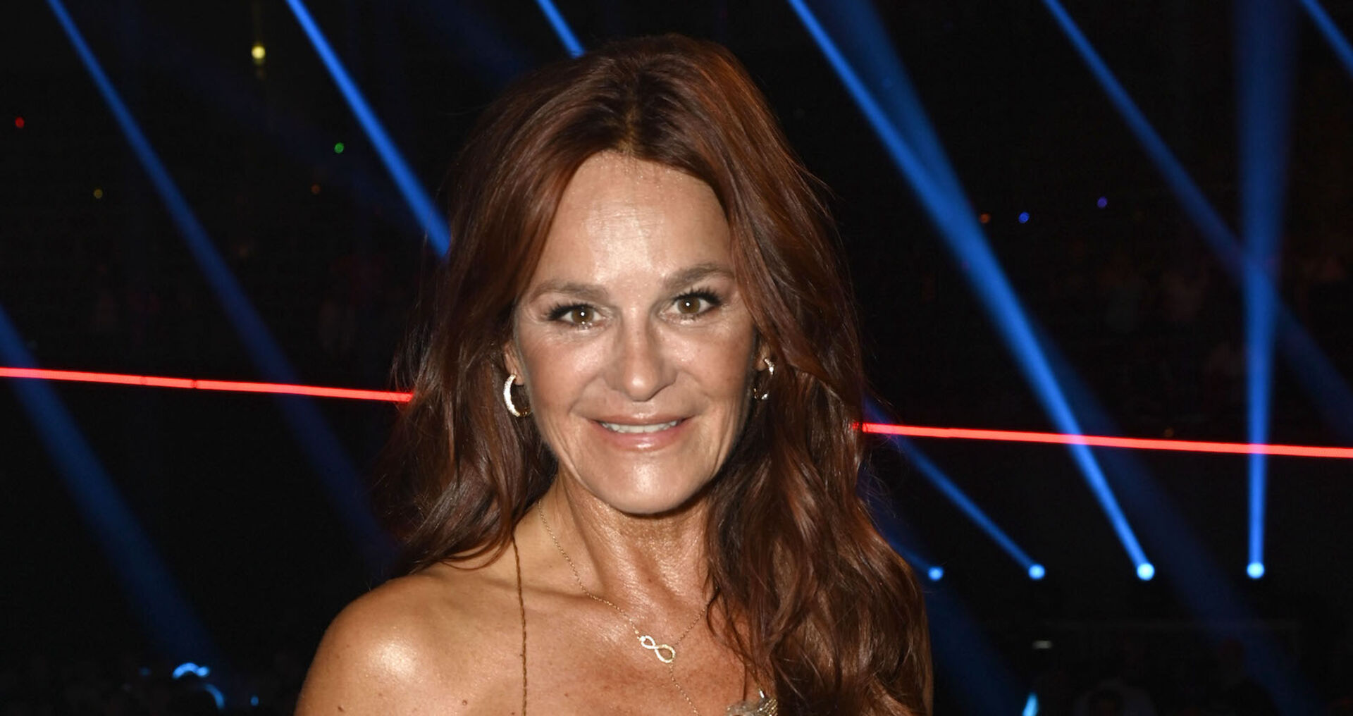Andrea Berg mit offenen langen Haaren vor einer Lasershow.