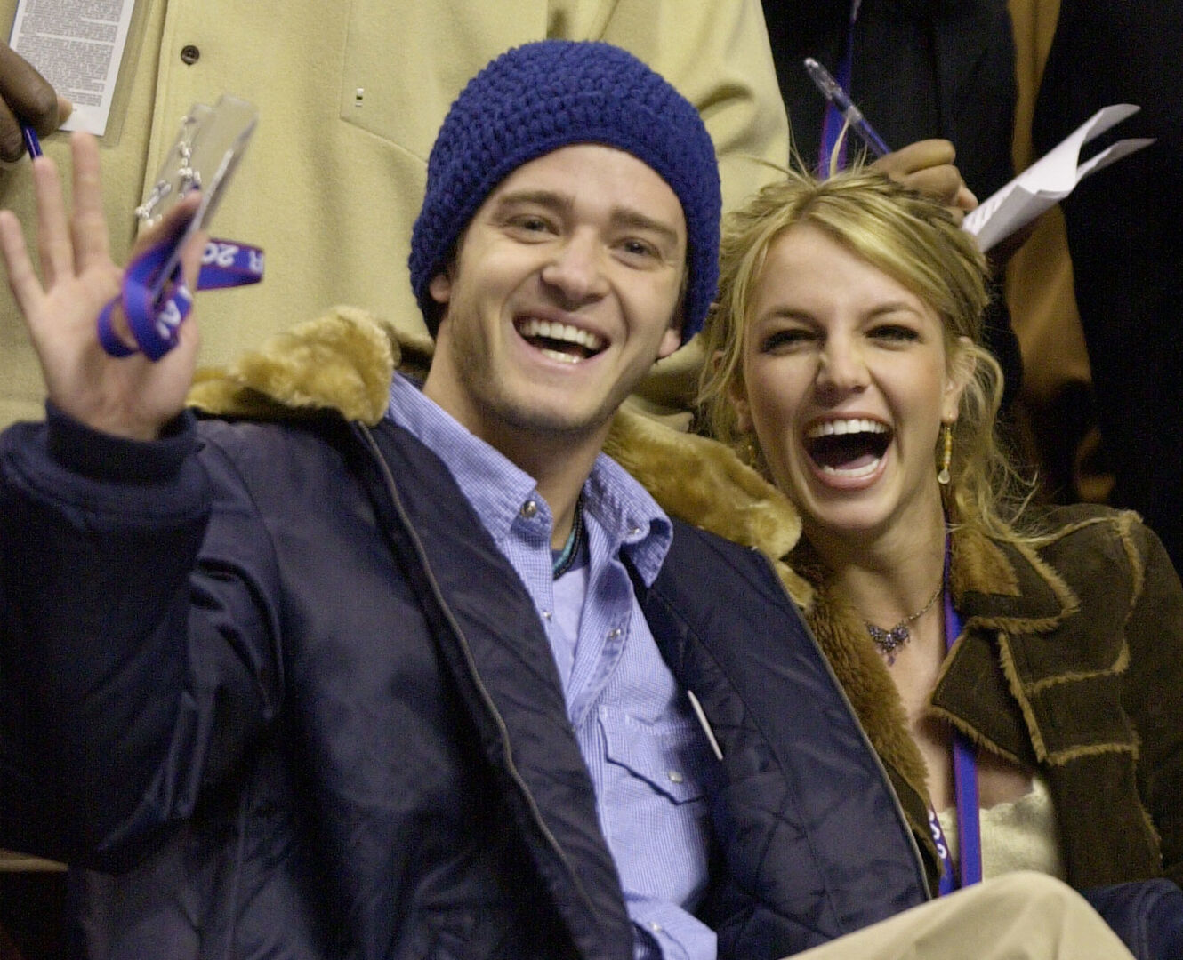 Justin Timberlake und Britney Spears in jungen Jahren als glückliches Paar in einem Publikum. Beide lachen in die Kamera