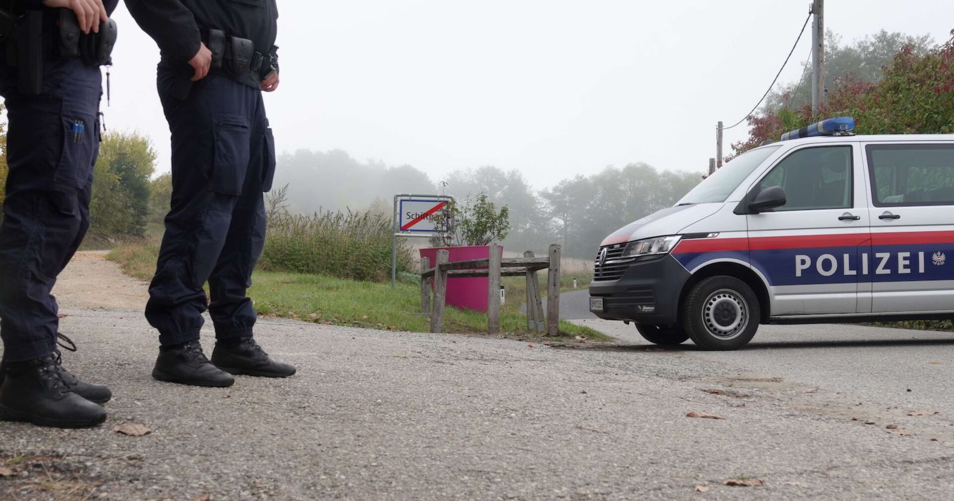 Zwei Polizisten und ein Polizeiauto.
