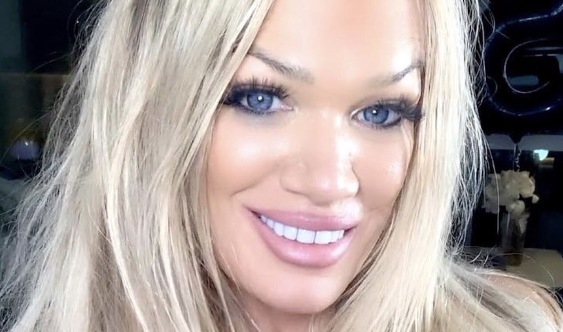 Eine blonde, starkgeschminkte Frau mit langen offenen Haaren.