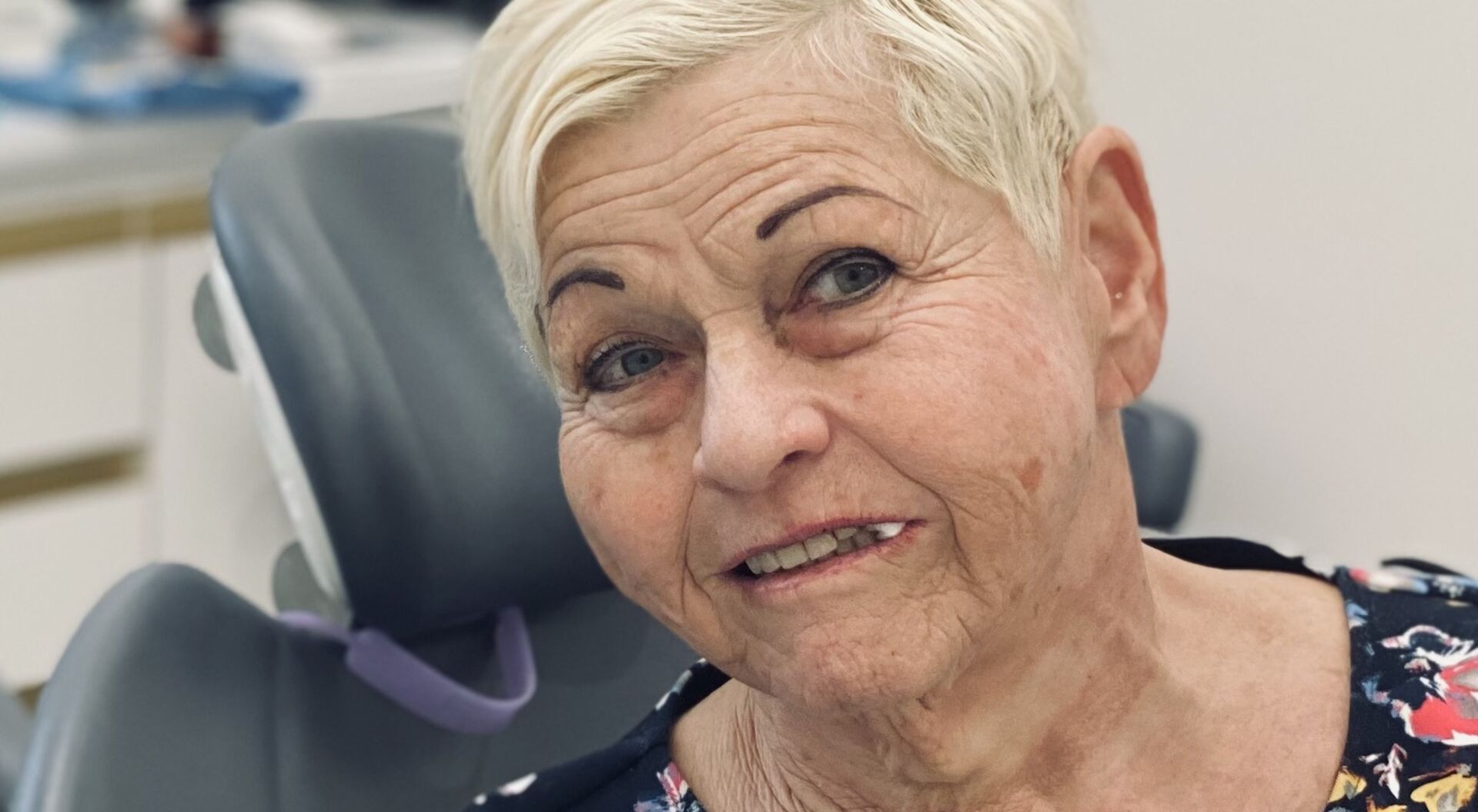 Sängerin Jazz Gitti mit kurzen blonden Haaren und einem Wattebausch im Mund beim Zahnarzt.