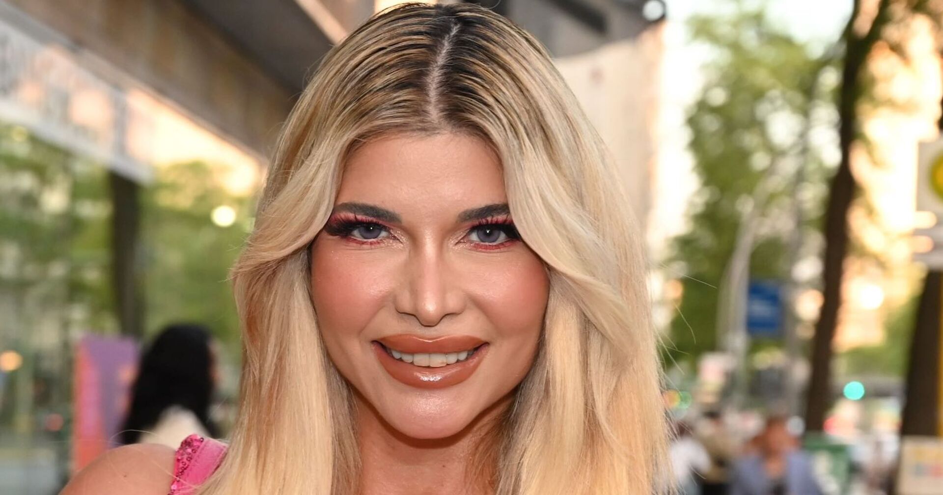 Michaela Schäfer mit blonden langen Haaren und viel Make Up auf der Straße.