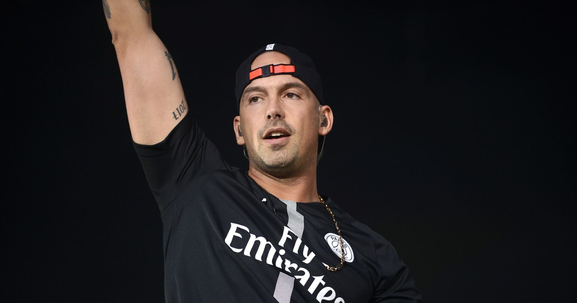 RAF Camora hebt die Hand zu seinem Publikum.