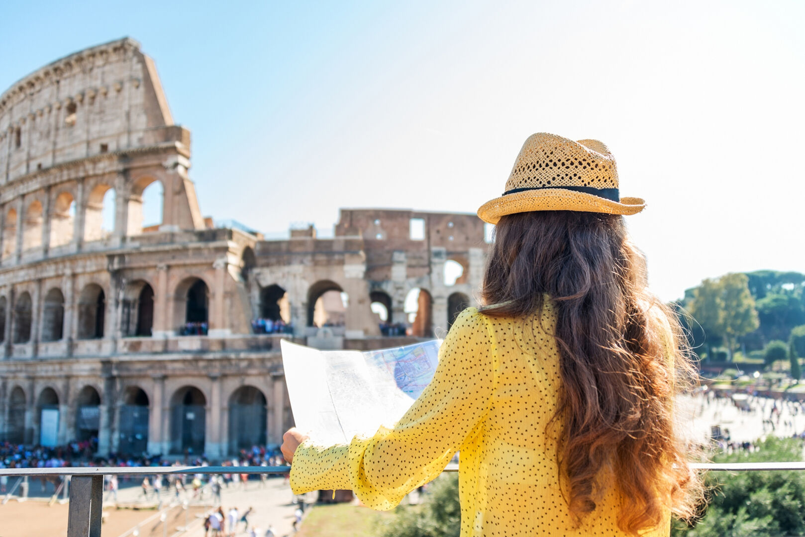 Frau steht vor dem Kolosseum in Rom | Credit: iStock.com/CentralITAlliance