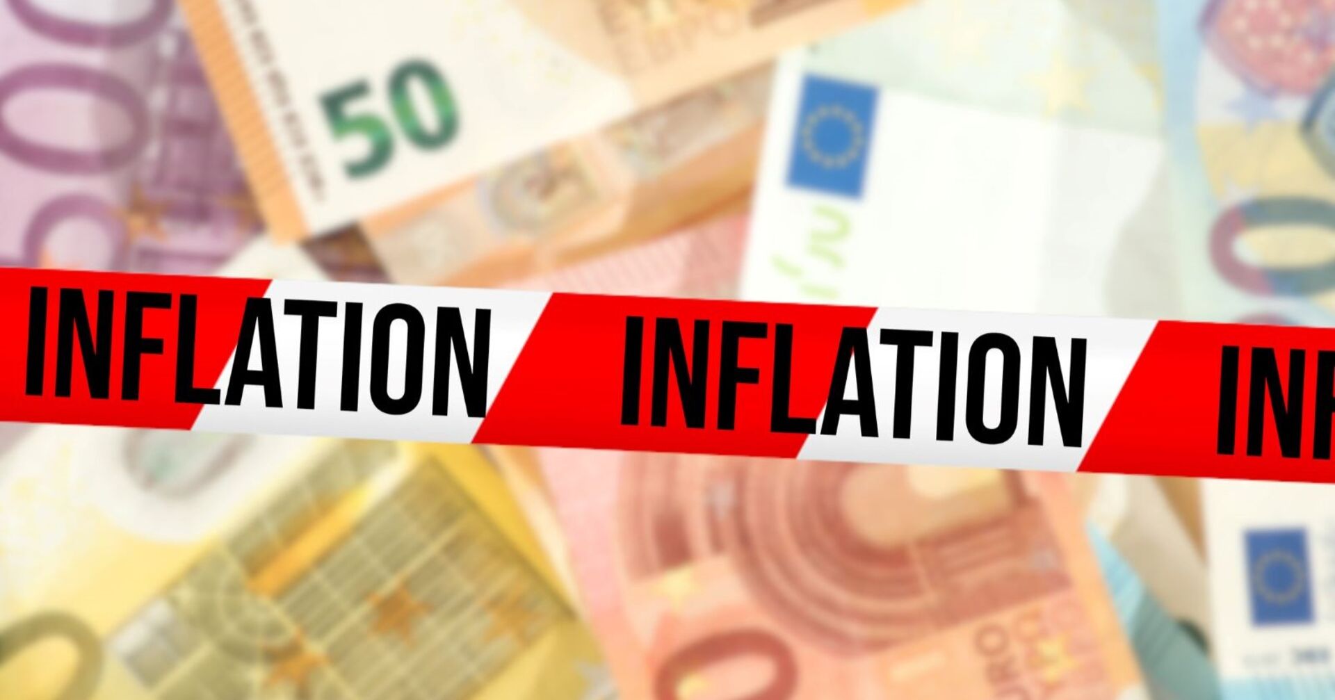 Mehrere Geldscheine übereinander, darüber ein Sperrband mit der Aufschritt "Inflation"