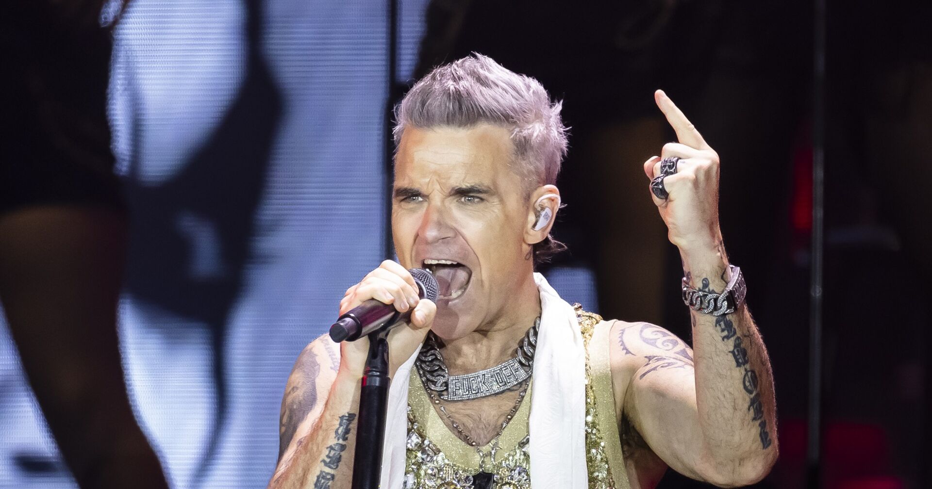 Robbie performt einen Song mit viel Energie auf der Bühne.