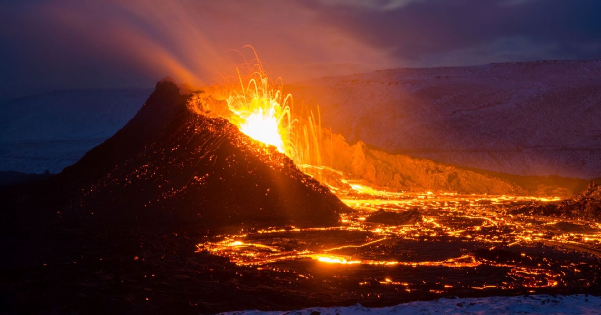 Ein isländischer Vulkan bei Nacht, der Asche und Lava spuckt.