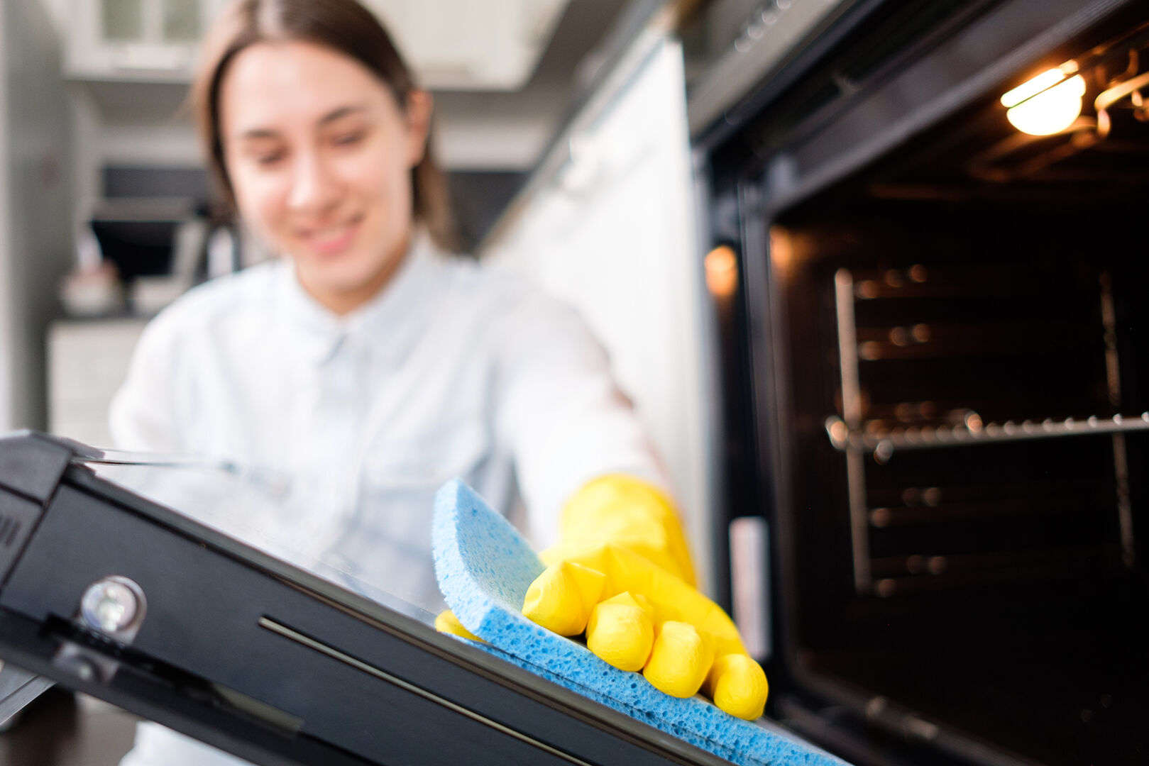 Frau reinigt Backofen | Credit: iStock.com/Alexander Medvedev