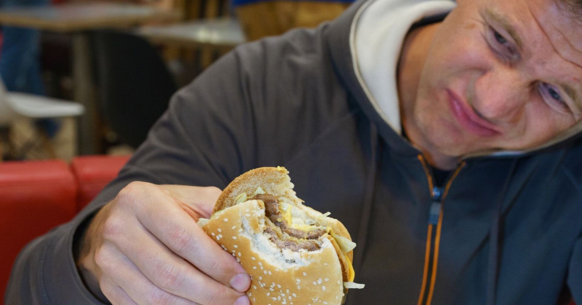 Mann ekelt sich vor einem Burger.