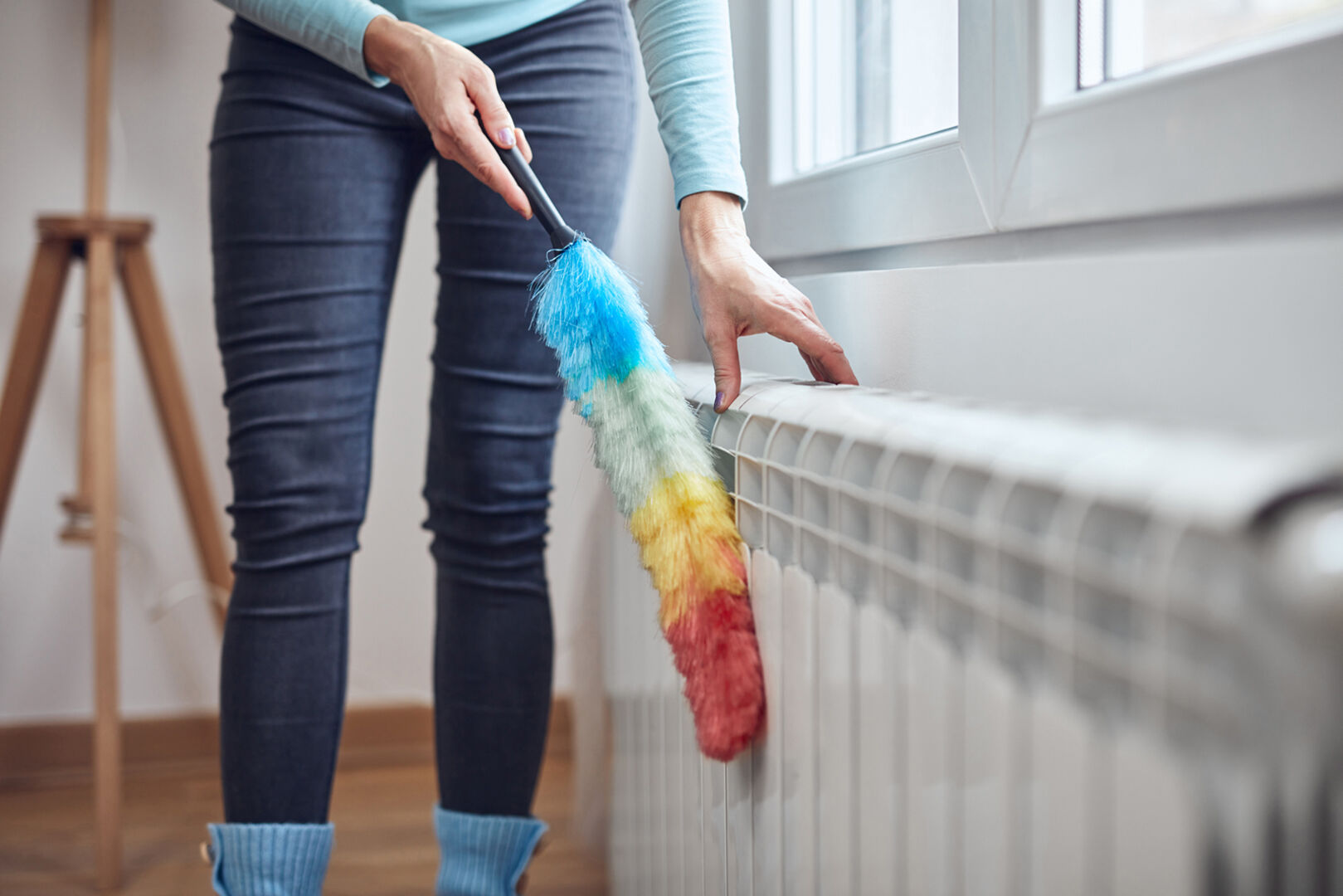 Frau reinigt Heizung | Credit: iStock.com/m-gucci