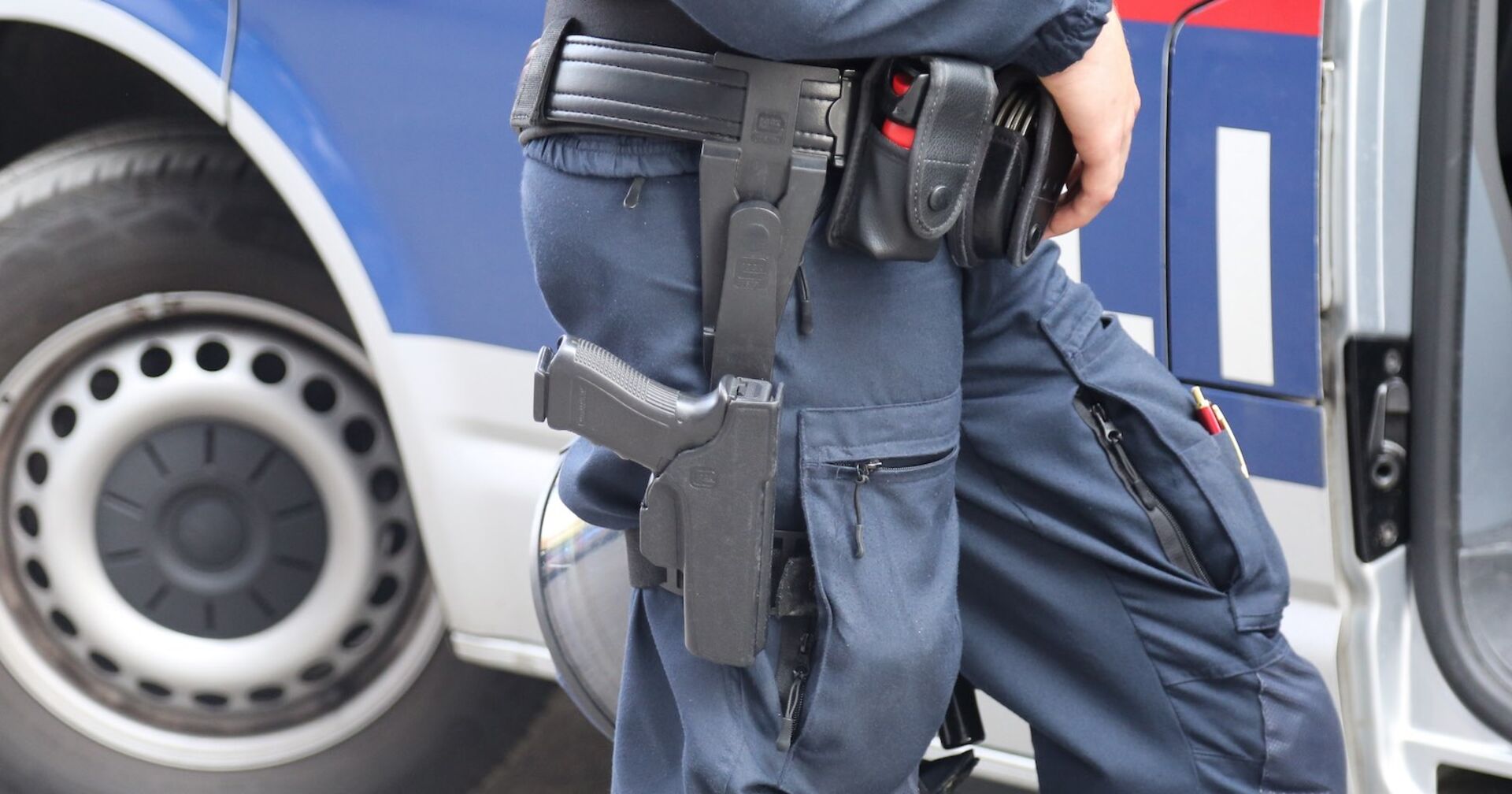 Polizeibeamter vor einem Polizeiauto.