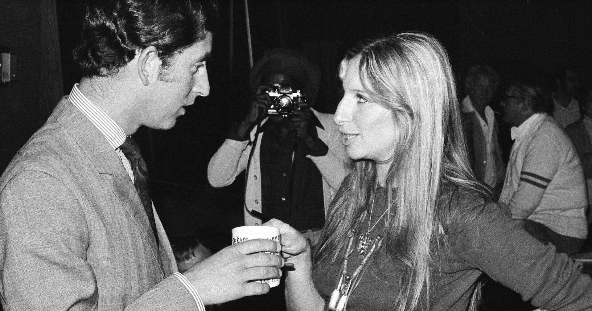 Prince Charles und Barbara Streisand im Jahre 1974 am Set von "FunnyGirl." Sie unterhalten sich und trinken eine Tasse Tee.