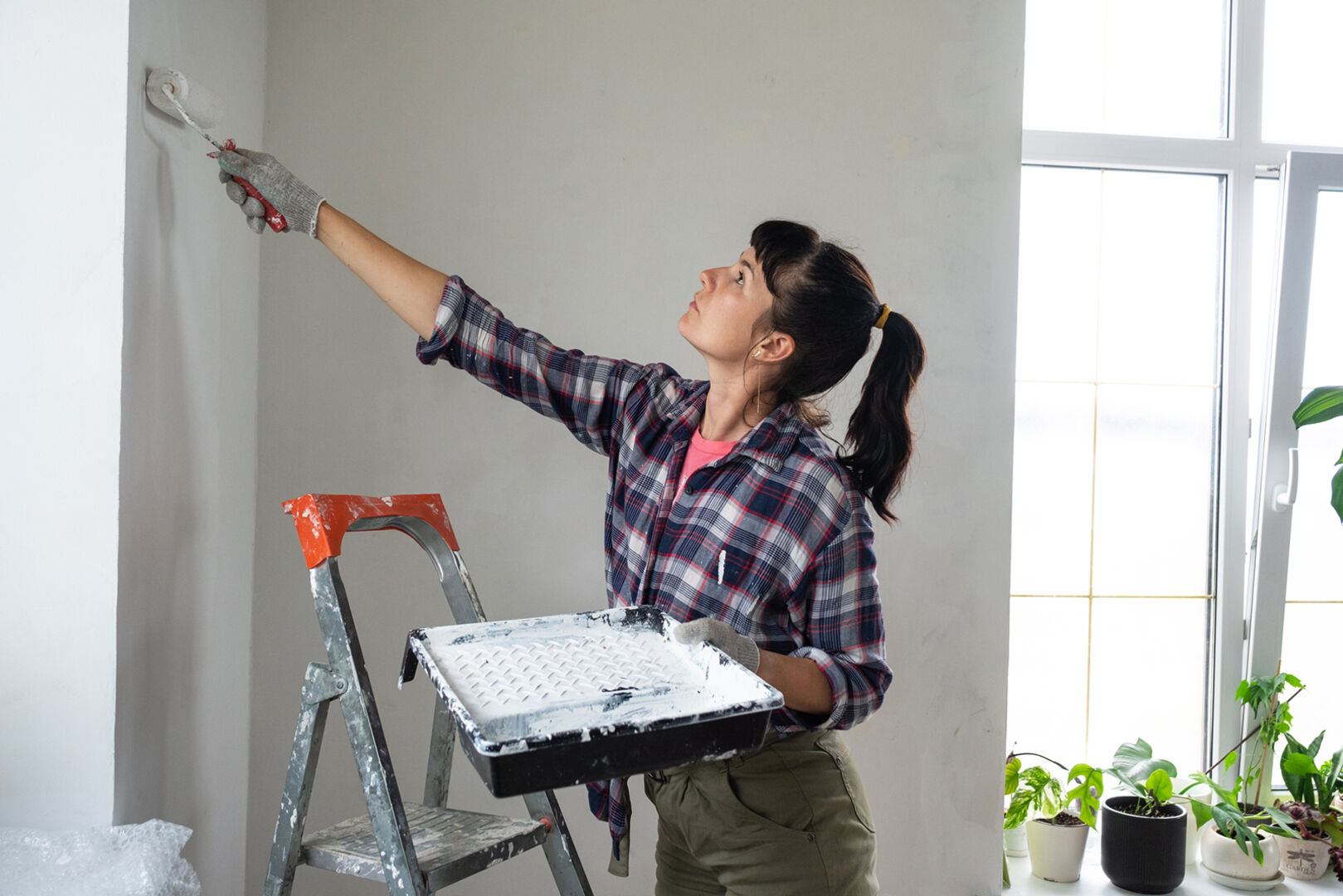 Frau streicht ihre Wohnung | Credit: iStock.com/Ольга Симонова
