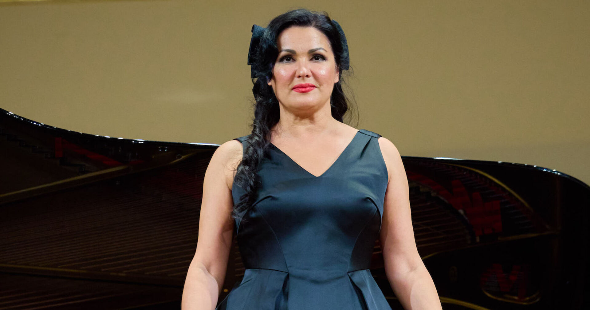 Anna Netrebko in einem blauen Ballkleid und einer eleganten Frisur.